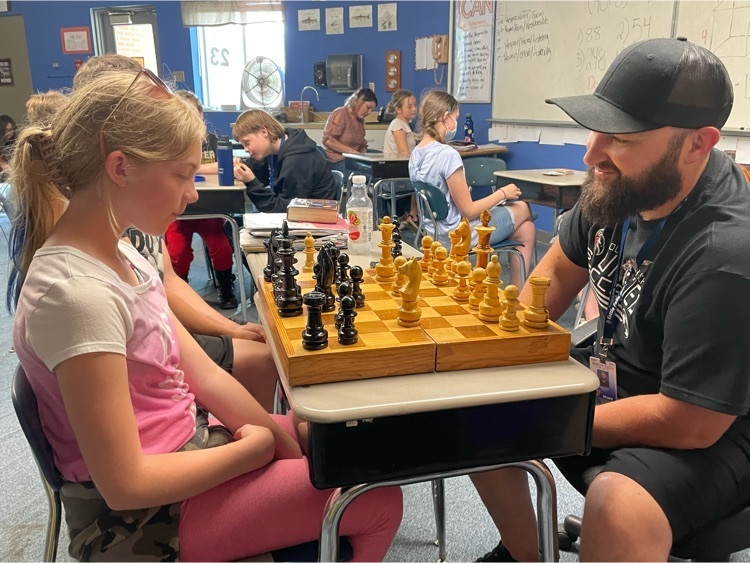 Mr. Rielly plays chess with a student  